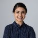 Head shot portrait smiling young Indian woman with arms crossed standing on grey studio background isolated, confident successful businesswoman or student with folded hands looking at camera