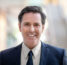 Portrait of happy mature businessman standing in office interior lobby smiling